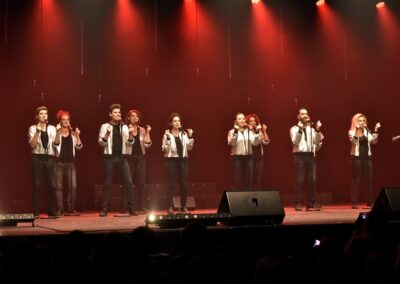 Groupe chantant sur scène sous lumières rouges
