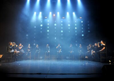 Groupe de chanteurs sur scène avec des lumières étoiles.