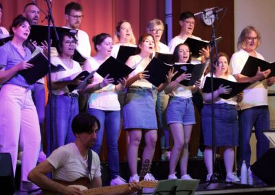 Chorale chantant sur scène avec un guitariste