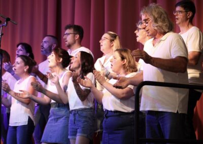 Chorale chantant sur scène en tenue blanche
